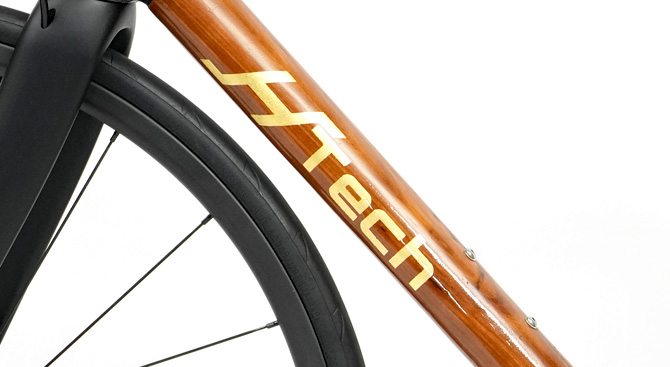 Light shining on gold leaf HTech logo on a HTech Puissant W made from Brown Mallet