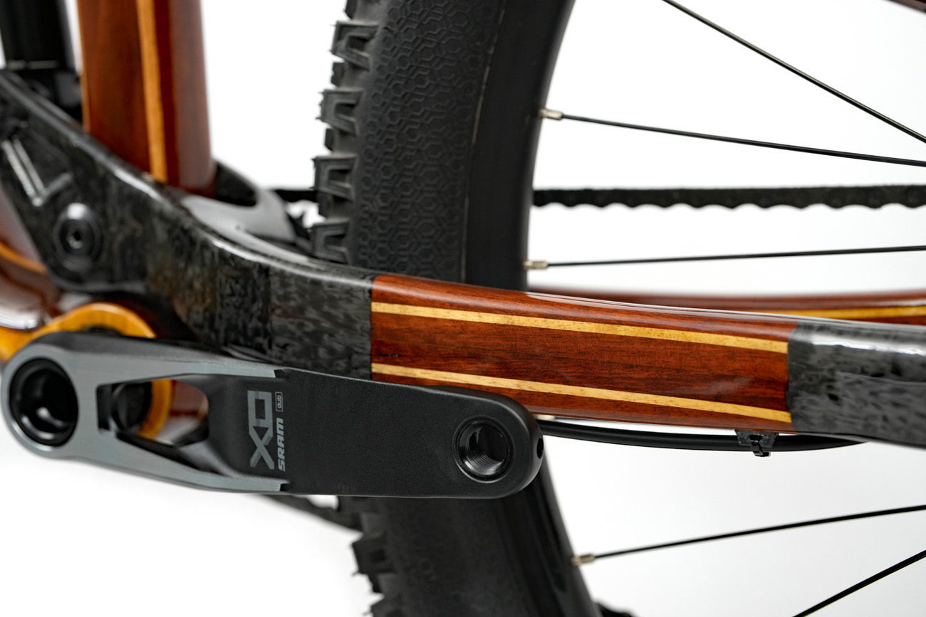 SRAM XO Transmission non-drive side crank with blended carbon fiber and wooden chain stay, showcasing different textures