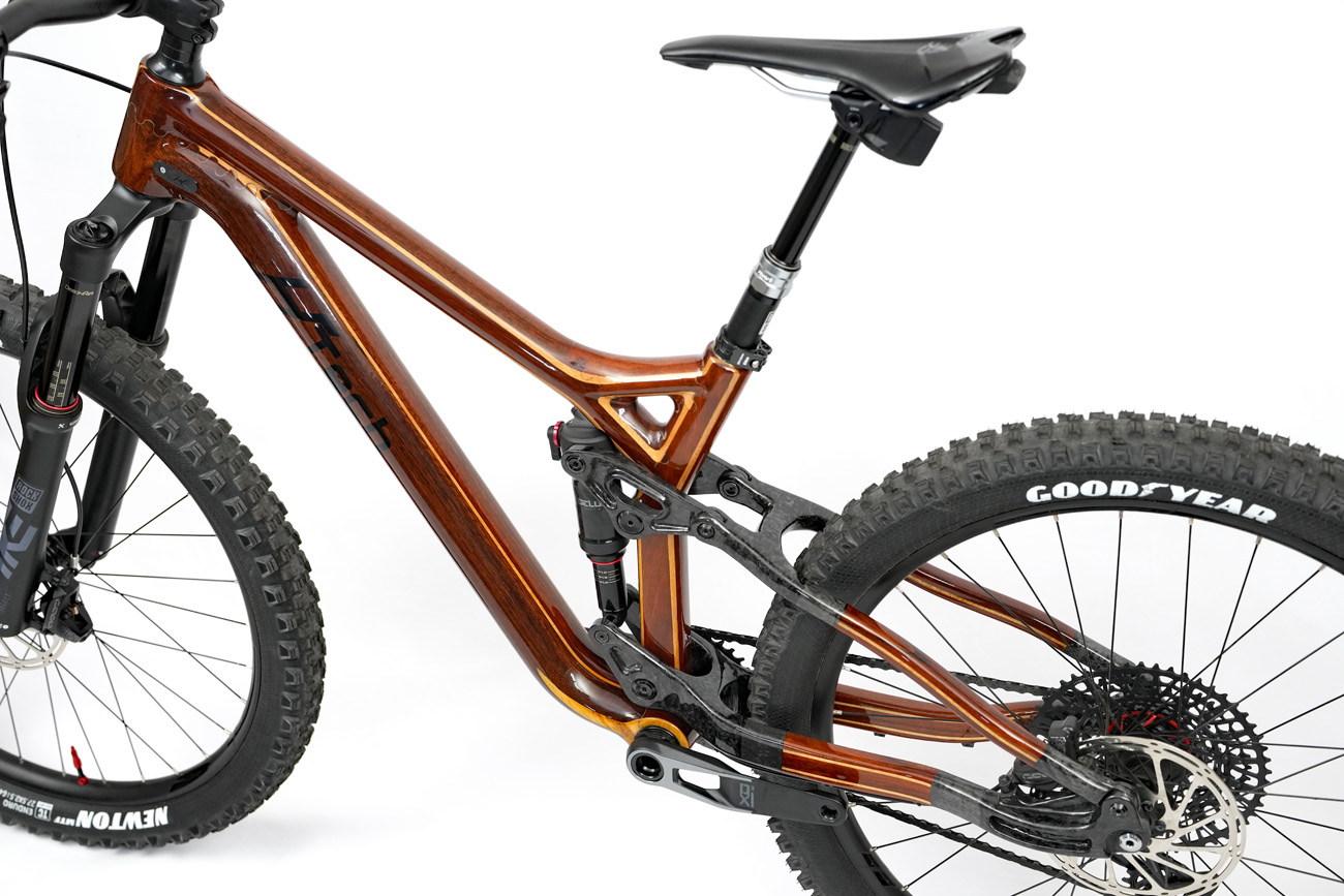 The full custom, carbon fiber and wood floating linkage suspension of a custom HTech enduro mountain bike