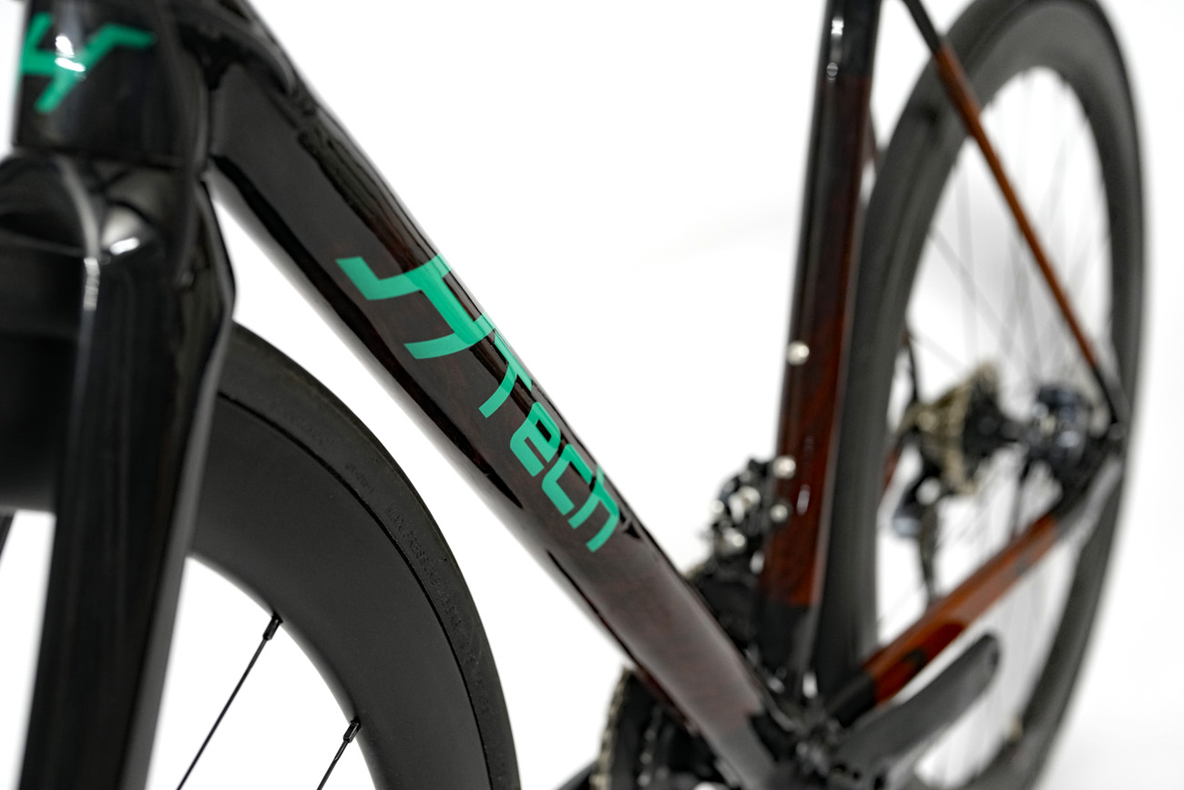 Down tube shot of a HTech Puissant made from Jarrah with green HTech logo